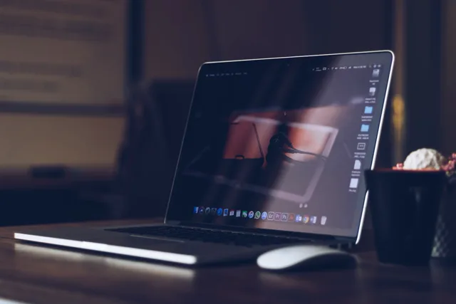 MacBook at a workstation — recovered footage back in post-production